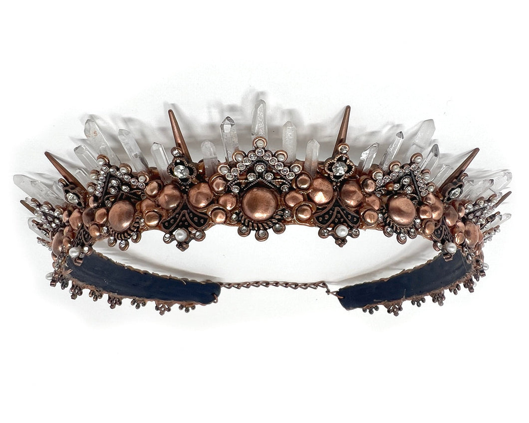 This ornate copper tiara may be dainty, but it is loaded with shining natural quartz crystals that playfully reflect the rays of the sun.  Five tiers of the quartz points cascade down to 1 inch tall copper spikes.  The filigree is accented with glittering rhinestones and iridescent freshwater pearls.  Perfect for the dance floor, whether it be concrete or the forest floor.